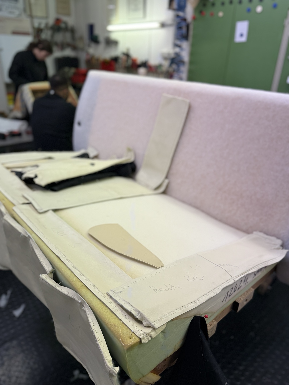 Polsterteile und Bezugszuschnitte auf einem Sofa in der Werkstatt