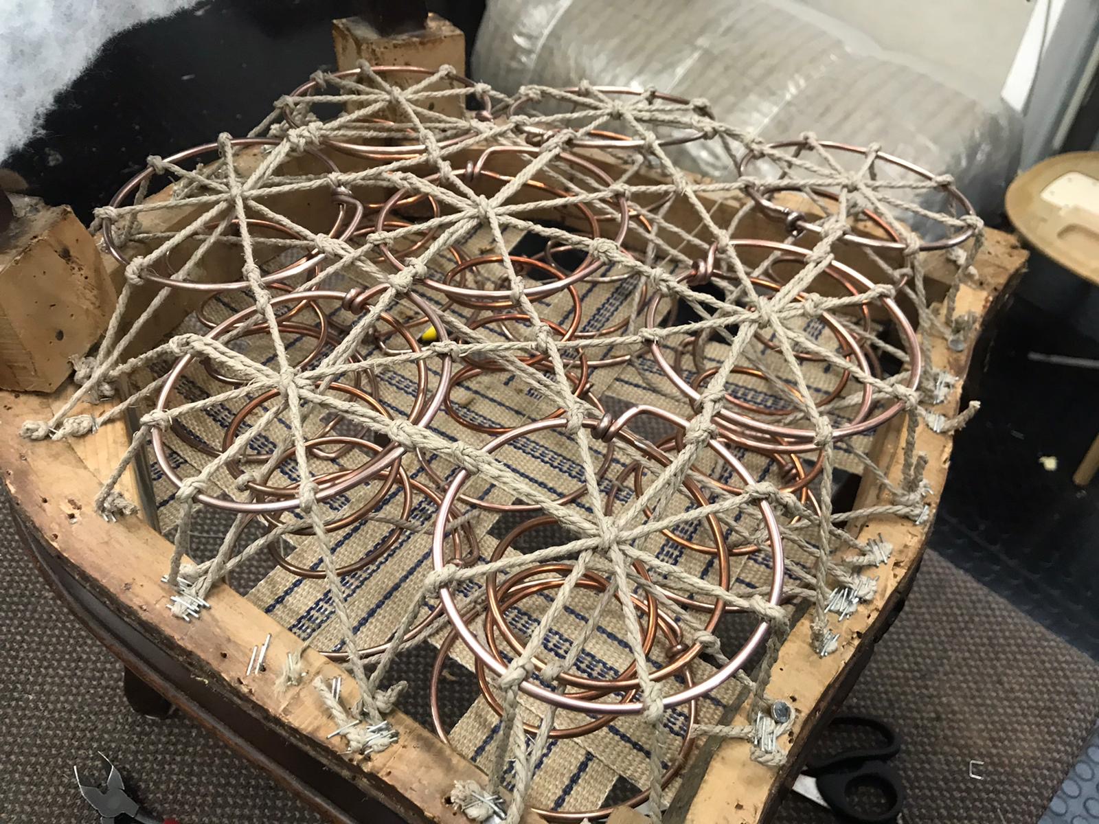 Mit Schnüren verbundene Metallfedern auf einer Gurtung