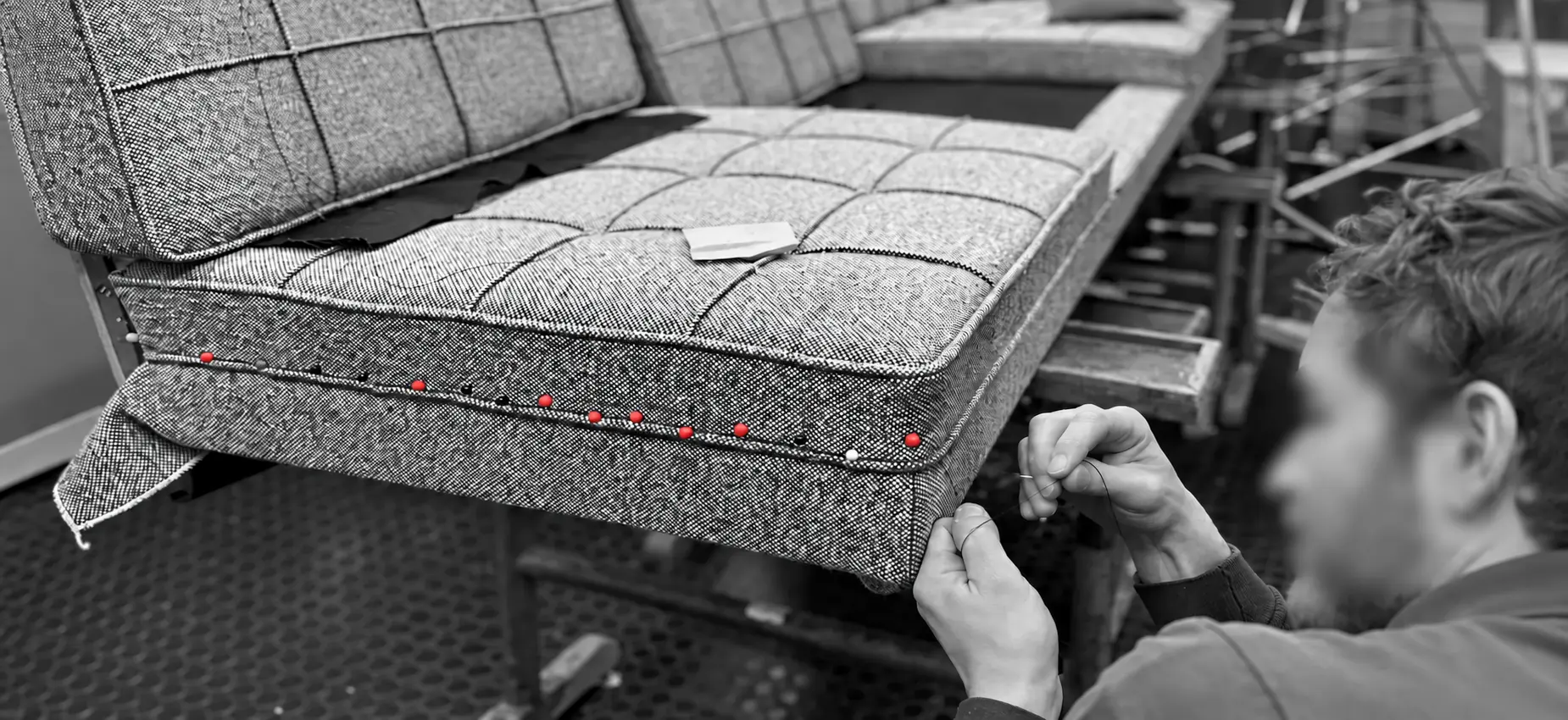 Handgenähte Bezugsarbeit mit roten Stecknadeln an einem Florence-Knoll-Sofa.