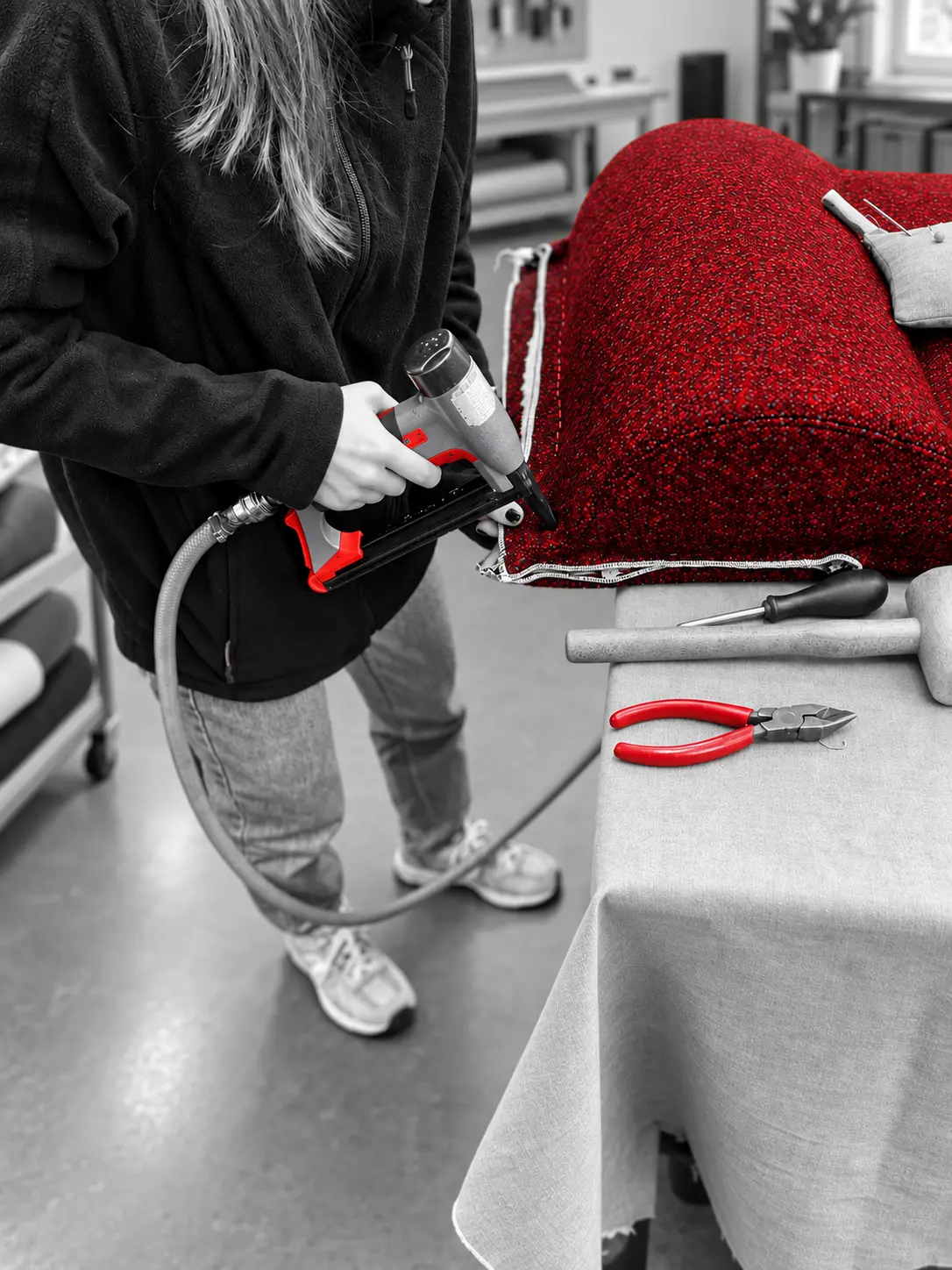 Roter Polsterbezug wird in der Werkstatt fachgerecht befestigt.